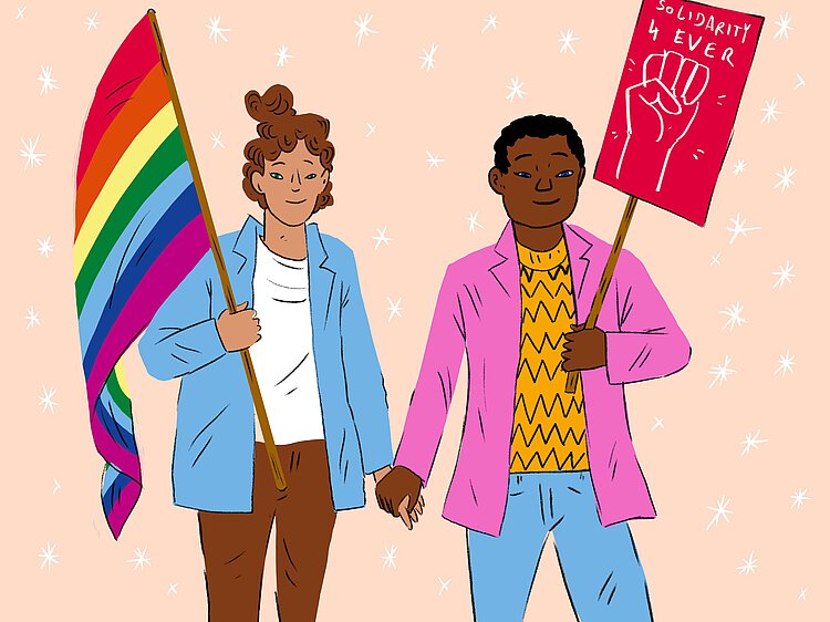 Zwei queere Personen halten sich an der Hand. Die Eine hält eine Regenbogenfahne, die andere ein Schild. 
