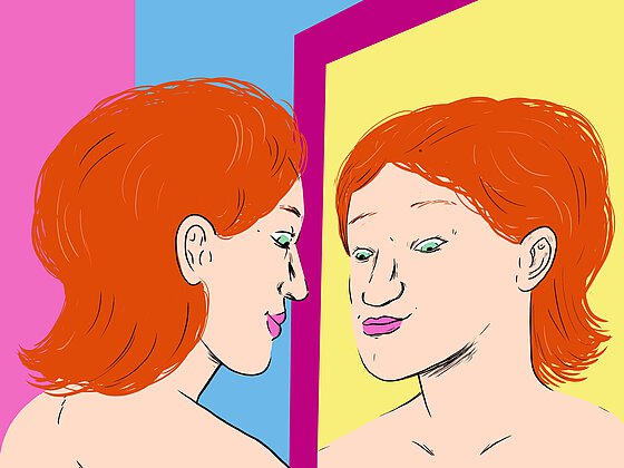 Eine Person mit schulterlangen roten Haaren schaut ihren Körper im Spiegel an. 