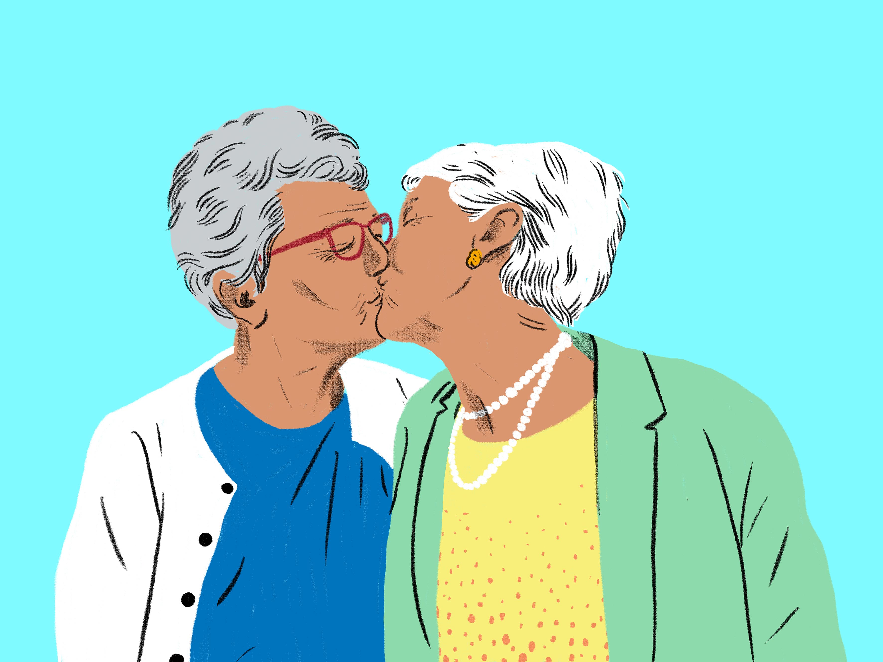 Zwei Seniorinnen küssen sich mit geschlossenen Augen auf den Mund. 